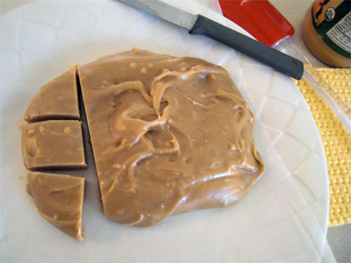 Cutting peanut butter fudge into pieces.